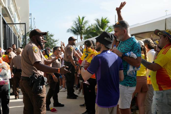 La policía habla con los aficionados fuera del estadio antes del partido final de la Copa América entre Argentina y Colombia en Miami Gardens, Florida, el domingo 14 de julio de 2024. (Foto AP/Lynne Sladky)