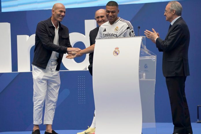 Kylian Mbappé es aplaudido por el presidente del Real Madrid, Florentino Pérez, y Zinedine Zidane, mientras es presentado como nuevo jugador del Real Madrid. (Foto AP/Andrea Comas)