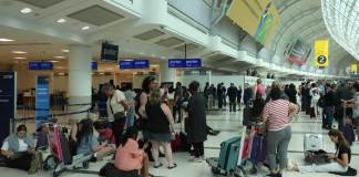 La gente se reúne alrededor del mostrador de facturación de Porter Airlines en el Aeropuerto Internacional Pearson de Toronto. (Chris Young/The Canadian Press vía AP)