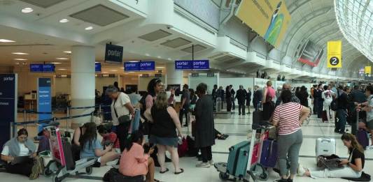 La gente se reúne alrededor del mostrador de facturación de Porter Airlines en el Aeropuerto Internacional Pearson de Toronto. (Chris Young/The Canadian Press vía AP)