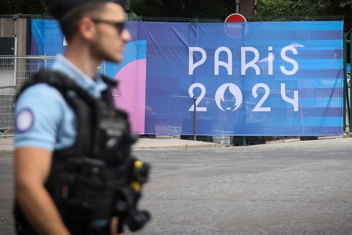 Un oficial de policía camina junto a un letrero de los Juegos Olímpicos de París el sábado 20 de julio del 2024. (AP Foto/Thomas Padilla)
