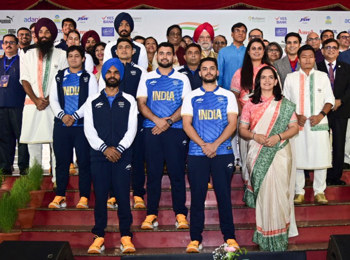 Esta imagen compartida por la Oficina de Información Pública muestra atletas indios posando con funcionarios mientras modelan los uniformes ceremoniales y de competencia de la India para los Juegos Olímpicos de París en Nueva Delhi, India, el domingo 30 de junio de 2024. (Press Information Bureau vía AP)