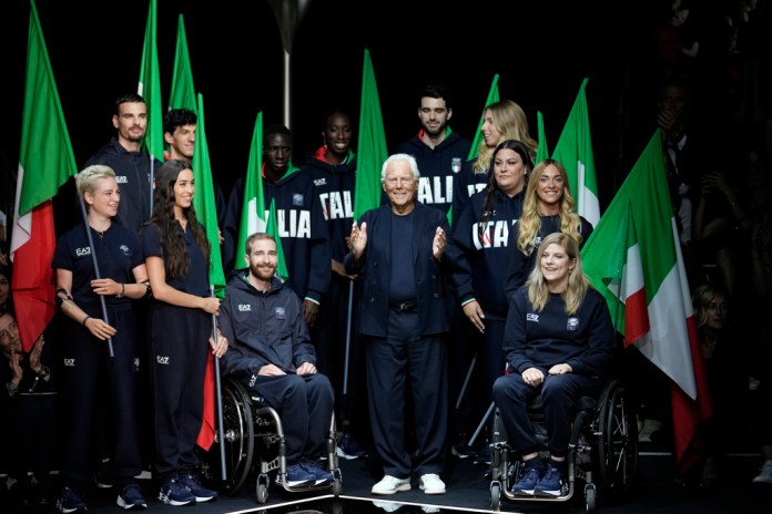 ARCHIVO- El diseñador Giorgio Armani recibe aplausos con el equipo paralímpico de Italia al final del desfile de la colección masculina Primavera Verano 2024 de Emporio Armani presentada en Milán, Italia, el 17 de junio de 2023. Los atletas italianos estarán elegantemente vestidos con uniformes de Emporio Armani, como lo han hecho en todos los Juegos Olímpicos desde 2012.(Foto AP/Luca Bruno, archivo)