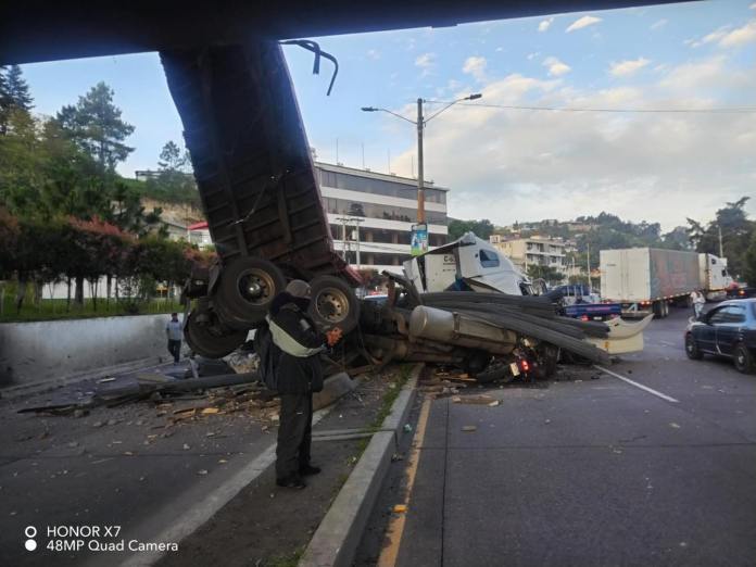 Una motocicleta quedó debajo del tráiler, cuando salía del desnivel. El motorista quedó ileso. Foto: Bomberos Voluntarios de Quetzaltenango