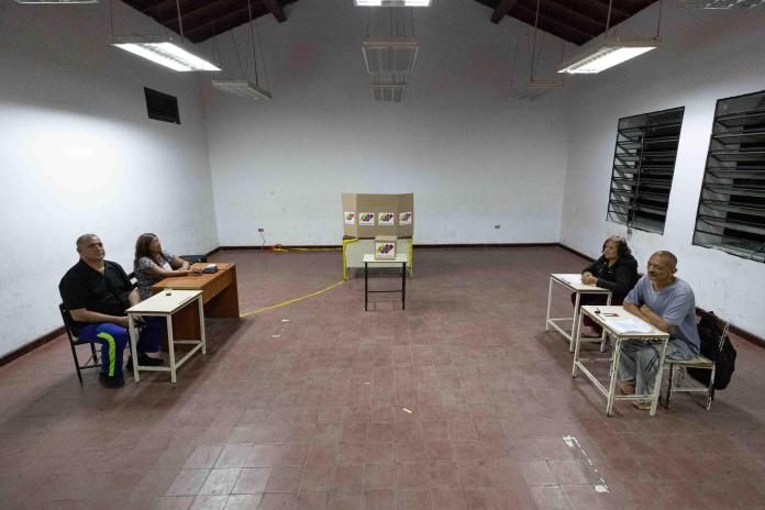 Personas esperan en un puesto de votación durante las elecciones presidenciales este domingo, en Caracas (Venezuela). EFE/ Ronald Peña R.