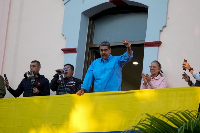 El presidente Nicolás Maduro hace gestos a sus seguidores durante un discurso desde un balcón del palacio presidencial en defensa de su reelección, en Caracas, Venezuela, el martes 30 de julio de 2024. (AP Foto/Fernando Vergara)