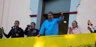 El presidente Nicolás Maduro hace gestos a sus seguidores durante un discurso desde un balcón del palacio presidencial en defensa de su reelección, en Caracas, Venezuela, el martes 30 de julio de 2024. (AP Foto/Fernando Vergara)