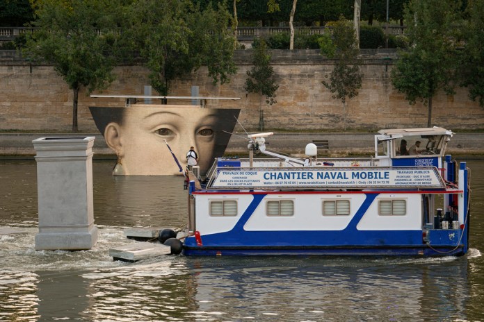 Un bote pasa junto a una reproducción artística en el río Sena durante los Juegos Olímpicos el martes 30 de julio del 2024. (AP Foto/Vadim Ghirda)