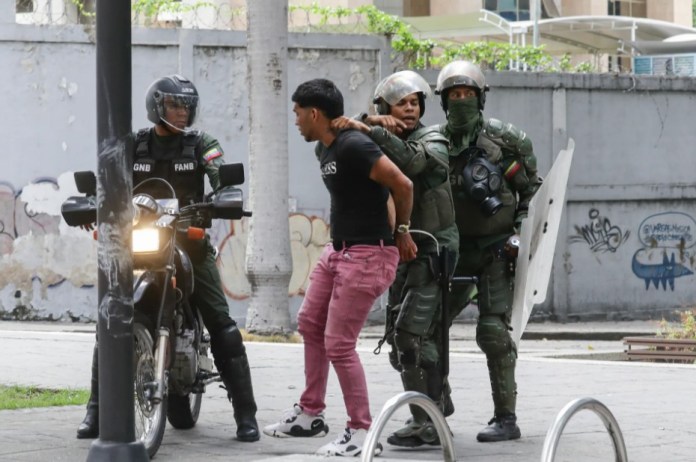 Integrantes de la Guardia Nacional Bolivariana detienen a un manifestante opositor, este martes, en Caracas (Venezuela). EFE/Ronald Peña