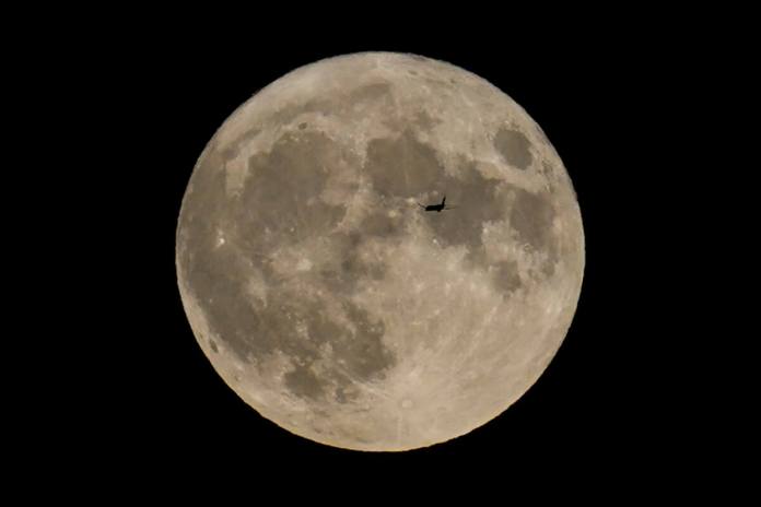 Un avión pasa frente a la Luna el 30 de agosto de 2023, en Chicago. (AP Foto/Kiichiro Sato, archivo)