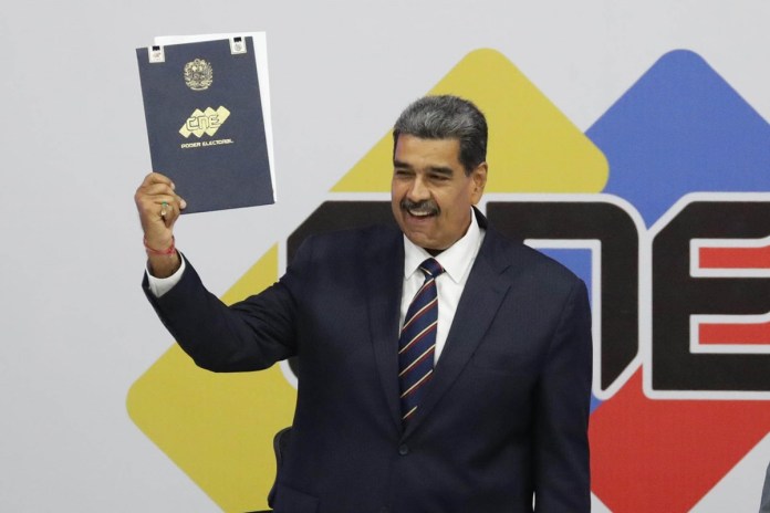 Nicolás Maduro sostiene el acta que lo proclama presidente reelecto por el Consejo Nacional Electoral (CNE) este lunes, en Caracas (Venezuela). EFE/ Ronald Peña R.