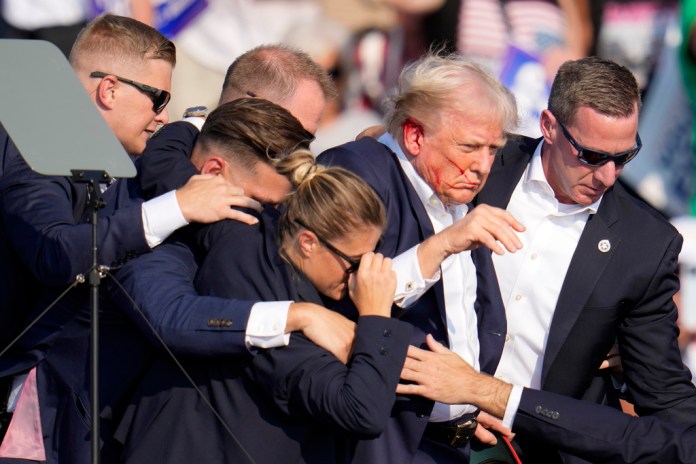 El candidato presidencial republicano, el expresidente Donald Trump, es ayudado a bajar del escenario por agentes del Servicio Secreto de Estados Unidos en un acto de campaña en Butler, Pensilvania, el sábado 13 de julio de 2024. (AP Foto/Gene J. Puskar)