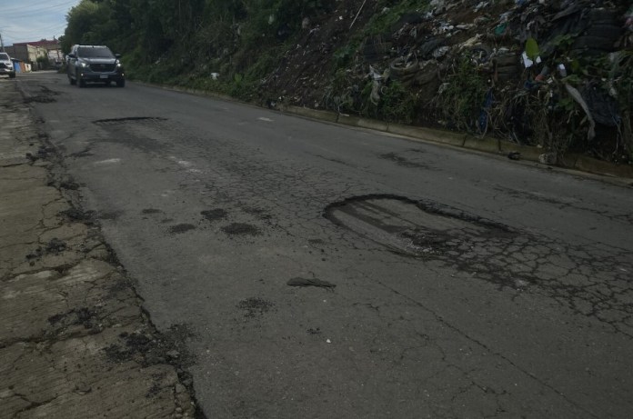 En parte de la ruta que fue asfaltada se observan baches los cuales revelan que la capa de asfalto vertida es muy delgada. Foto: La Hora / José Orozco. 