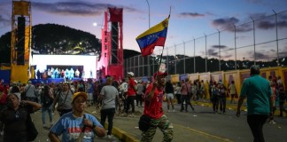 Un partidario del presidente Nicolás Maduro sostiene una bandera venezolana después de un mitin de campaña en el barrio de Catia en Caracas, Venezuela, el jueves 18 de julio de 2024. Venezuela celebrará elecciones presidenciales el 28 de julio. (Foto AP/Matias Delacroix)