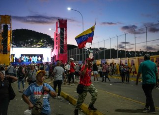 Un partidario del presidente Nicolás Maduro sostiene una bandera venezolana después de un mitin de campaña en el barrio de Catia en Caracas, Venezuela, el jueves 18 de julio de 2024. Venezuela celebrará elecciones presidenciales el 28 de julio. (Foto AP/Matias Delacroix)