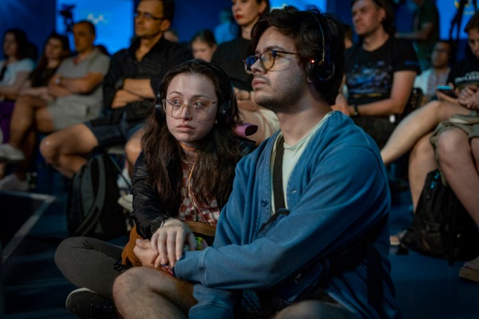 Un grupo de personas escucha una charla pública en la Casa de Ucrania en París, Francia, el domingo 4 de agosto de 2024. (AP Foto/Hanna Arhirova)