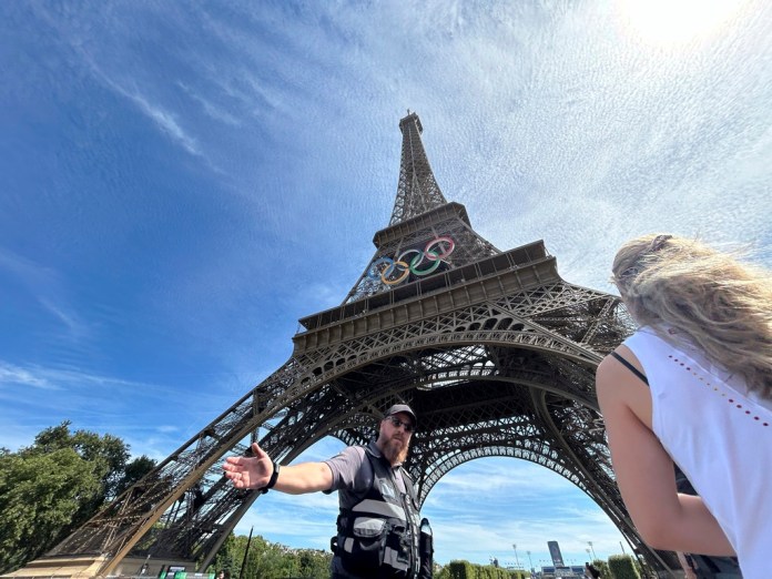 La policía evacúa los alrededores de la Torre Eiffel luego que un individuo fue visto escalando el icónico monumento de París, el domingo 11 de agosto de 2024. (AP Foto/Aijaz Rahi)