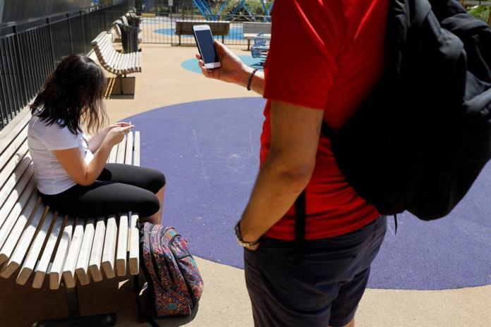 Fotografía de archivo en donde se ven jóvenes que usan sus teléfonos en un parque. EFE/ Sebastien Nogier