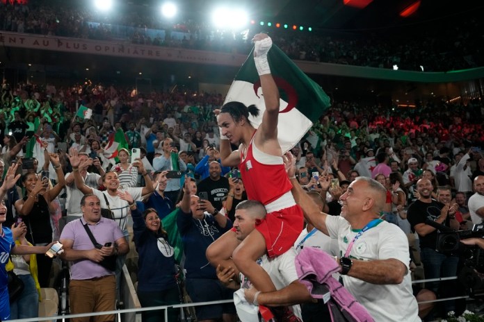 La boxeadora argelina Imane Khelif es llevada en hombros tras vencer a la china Yang Liu para ganar la medalla de oro en la categoría de los 66 kilogramos de los Juegos Olímpicos, el viernes 9 de agosto de 2024, en París (AP Foto/Ariana Cubillos)