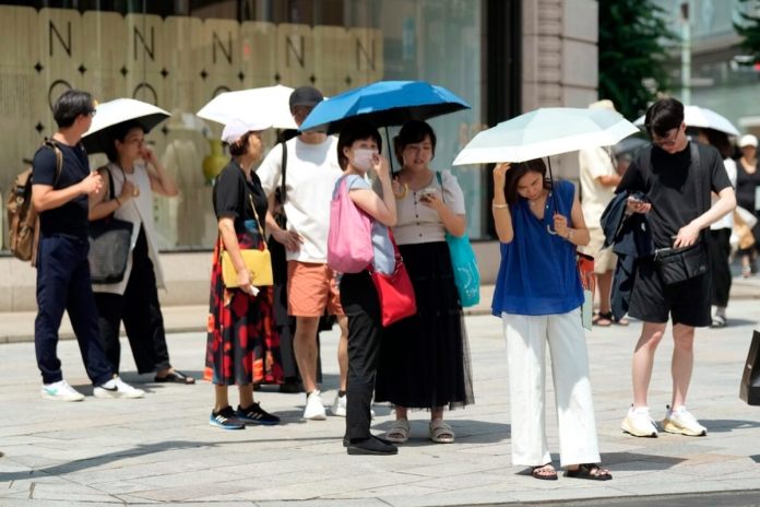 Peatones usan sombrillas para protegerse del calor en la avenida comercial Ginza de Tokio, el 8 de julio de 2024. (AP Foto/Eugene Hoshiko, archivo)