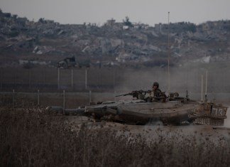 Soldados israelíes a bordo de un tanque cerca de la frontera entre Israel y Gaza, en una imagen tomada desde el sur de Israel, el miércoles 21 de agosto de 2024. (AP Foto/Leo Correa)