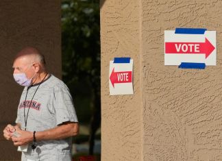 Un trabajador del distrito electoral sale de una casilla de votación durante las primarias estatales, el martes 30 de julio de 2024, en Sun City West, Arizona. (AP Foto/Ross D. Franklin)