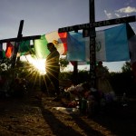 ARCHIVO – Dolientes visitan un monumento improvisado en honor a las víctimas y sobrevivientes de una tragedia de tráfico humano, en la que docenas de migrantes fueron hallados muertos una semana antes en el remolque de un camión, el 6 de julio de 2022 en San Antonio. (AP Foto/Eric Gay, Archivo)
