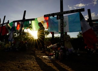 ARCHIVO – Dolientes visitan un monumento improvisado en honor a las víctimas y sobrevivientes de una tragedia de tráfico humano, en la que docenas de migrantes fueron hallados muertos una semana antes en el remolque de un camión, el 6 de julio de 2022 en San Antonio. (AP Foto/Eric Gay, Archivo)