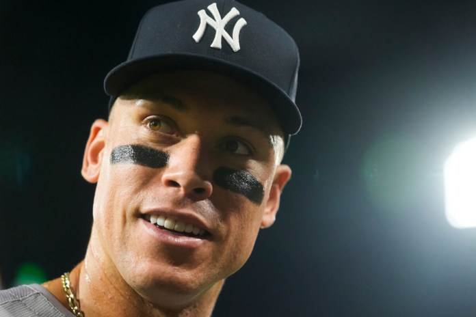 Aaron Judge, de los Yankees de Nueva York, hace señas a los fanáticos después de conectar su jonrón número 300 de su carrera, el jugador más rápido en lograrlo en la historia de la MLB, en un juego de béisbol contra los Medias Blancas de Chicago, el miércoles 14 de agosto de 2024, en Chicago. (Foto AP/Erin Hooley)