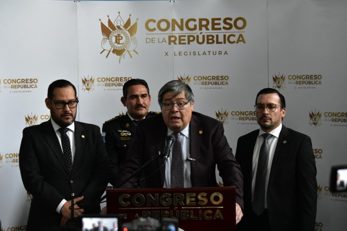 El ministro de Gobernación, Francisco Jiménez, es acompañado en el Congreso de la República, por el segundo viceministro, Felipe Sánchez (derecha), el quinto viceministro, Werner Ovalle (izquierda), y el director adjunto de la Policía Nacional Civil, Helver Beltetón (fondo). Foto: Daniel Ramírez