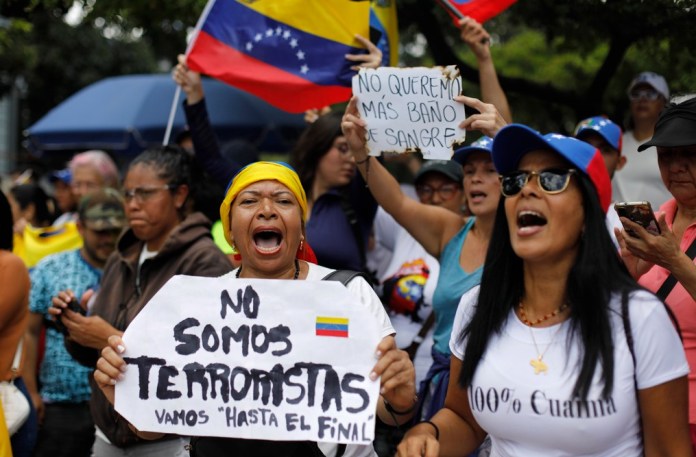 Una mujer sostiene un cartel con un mensaje que dice 