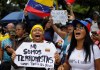 Una mujer sostiene un cartel con un mensaje que dice "No somos terroristas. Vamos hasta el final", mientras espera junto a sus compañeros partidarios la llegada de la líder opositora María Corina Machado, en Caracas, Venezuela, el sábado 3 de agosto de 2024. (Foto AP/Cristian Hernández)