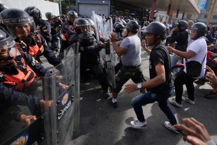 Los manifestantes cargan contra la policía durante manifestaciones contra los resultados oficiales de las elecciones, un día después de que las autoridades electorales declararan vencedor de los comicios al presidente Nicolás Maduro en Caracas, Venezuela, el lunes 29 de julio de 2024. (AP Foto/Fernando Vergara)