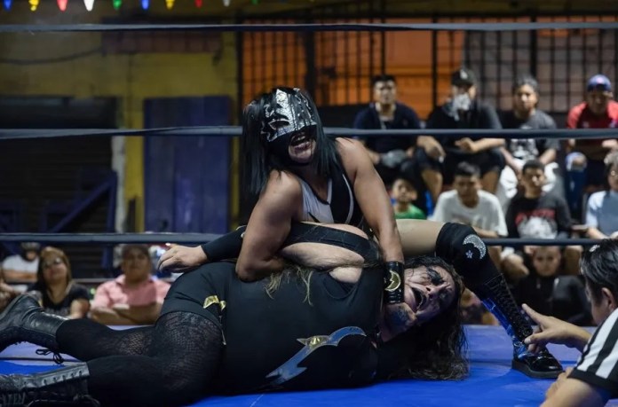 La luchadora guatemalteca Princesa Luna aplica una llave a su contrincante salvadoreña, La Metálica, durante un combate estelar de la lucha libre en la Ciudad de Guatemala (Guatemala). EFE/David Toro