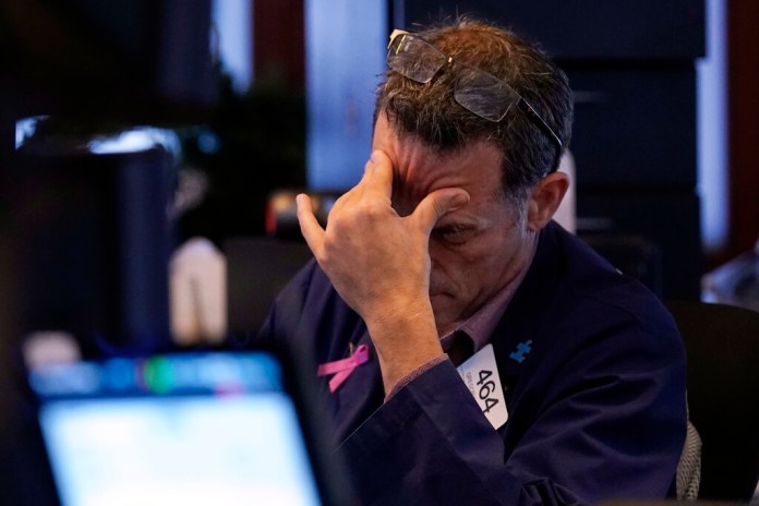 El operador bursátil Gregory Rowe trabajando en el piso de remates de la Bolsa de Valores de Nueva York, el lunes 5 de agosto de 2024. (Foto AP/Richard Drew)