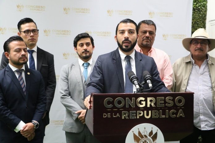 El diputado NapoleÃ³n Rojas, y su compaÃ±ero Ricardo MartÃ­nez AlarcÃ³n (saco gris), firmaron la iniciativa de ley para reformar la distribuciÃ³n de las utilidades de la Empresa Portuaria Quetzal. Foto: Congreso