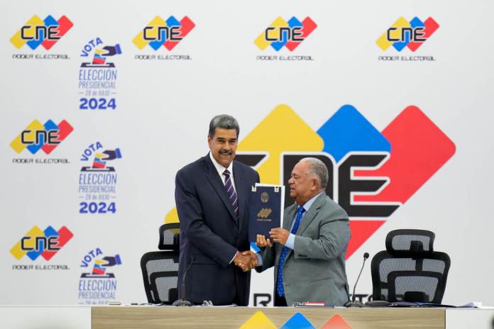 El presidente venezolano Nicolás Maduro, a la izquierda, recibe la certificación del presidente del Consejo Nacional Electoral (CNE). (AP Foto/Matías Delacroix)