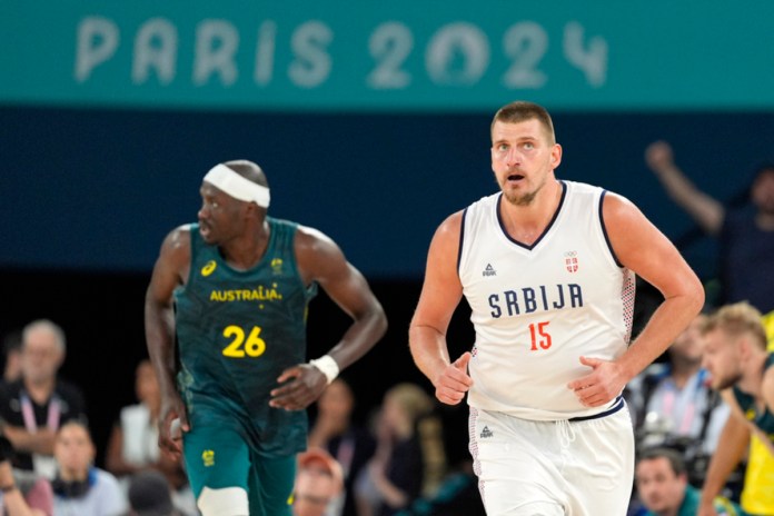 El serbio Nikola Jokic (derecha) corre por la cancha mientras el australiano Duop Reath corre detrás durante un partido de cuartos de final en el Bercy Arena de los Juegos Olímpicos de Verano de 2024, el martes 6 de agosto de 2024, en París, Francia. (Foto AP/Michael Conroy)