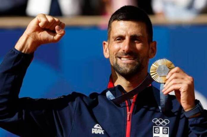 PARIS, 04/08/2024.- El tenista serbio Novak Djokovic posa con la medalla de oro en el podio tras la final individual masculina de tenis de los Juegos Olímpicos de París 2024 este domingo, en la capital gala. EFE/Juanjo Martín