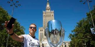 Aficionados del Real Madrid se hacen fotos junto una réplica del trofeo de la Supercopa junto a la Torre de la Ciencia de Varsovia poco antes del partido que disputarán el Real Madrid y el Atalanta en el estadio Narodowy de la capital polaca hoy 14 de agosto 2024. EFE/ Mariscal