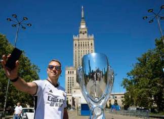 Aficionados del Real Madrid se hacen fotos junto una réplica del trofeo de la Supercopa junto a la Torre de la Ciencia de Varsovia poco antes del partido que disputarán el Real Madrid y el Atalanta en el estadio Narodowy de la capital polaca hoy 14 de agosto 2024. EFE/ Mariscal