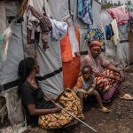 Un grupo de personas en el campo de refugiados Don Bosco, mientras funcionarios de la Cruz Roja crean conciencia sobre el mpox en Goma, República Democrática del Congo, el jueves 22 de agosto de 2023. (AP Foto/Moses Sawasawa)