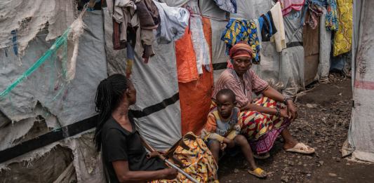 Un grupo de personas en el campo de refugiados Don Bosco, mientras funcionarios de la Cruz Roja crean conciencia sobre el mpox en Goma, República Democrática del Congo, el jueves 22 de agosto de 2023. (AP Foto/Moses Sawasawa)