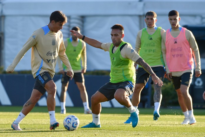 El argentino Paulo Dybala, a la izquierda, controla el balón bajo la presión de Lautaro Martínez durante una sesión de entrenamiento para un próximo partido de clasificación para la Copa del Mundo contra Chile, en Buenos Aires, Argentina, el martes 3 de septiembre de 2024. (Foto AP/Gustavo Garello)