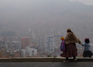 Archivo - Una mujer acompaña a su hija a la escuela en medio del humo de los incendios forestales en La Paz, Bolivia, el lunes 9 de septiembre de 2024. (AP Foto/Juan Karita, archivo)