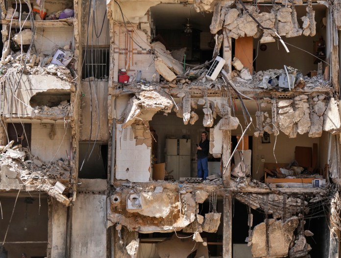 Un hombre observa a los rescatistas mientras revisan entre los escombros en busca de personas desaparecidas tras el ataque israelí del viernes sobre los suburbios del sur de Beirut, el lunes 23 de septiembre de 2024. (AP Foto/Hassan Ammar)