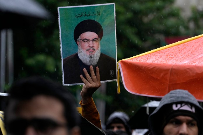 Un manifestante iraní sostiene un cartel del líder del grupo político-paramilitar libanés Hezbollah, Hassan Nasrallah, en una concentración en apoyo a Hezbollah en la plaza Felestin (Palestina), en el centro de Teherán, Irán, el sábado 28 de septiembre de 2024. (Foto AP/Vahid Salemi)