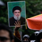 Un manifestante iraní sostiene un cartel del líder del grupo político-paramilitar libanés Hezbollah, Hassan Nasrallah, en una concentración en apoyo a Hezbollah en la plaza Felestin (Palestina), en el centro de Teherán, Irán, el sábado 28 de septiembre de 2024. (Foto AP/Vahid Salemi)