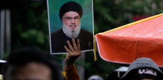 Un manifestante iraní sostiene un cartel del líder del grupo político-paramilitar libanés Hezbollah, Hassan Nasrallah, en una concentración en apoyo a Hezbollah en la plaza Felestin (Palestina), en el centro de Teherán, Irán, el sábado 28 de septiembre de 2024. (Foto AP/Vahid Salemi)