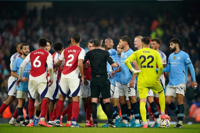 Los jugadores chocan hacia el final del partido de fútbol de la Liga Premier inglesa entre el Manchester City y el Arsenal en el estadio Etihad en Manchester, Inglaterra, el domingo 22 de septiembre de 2024. (Foto AP/Dave Thompson)